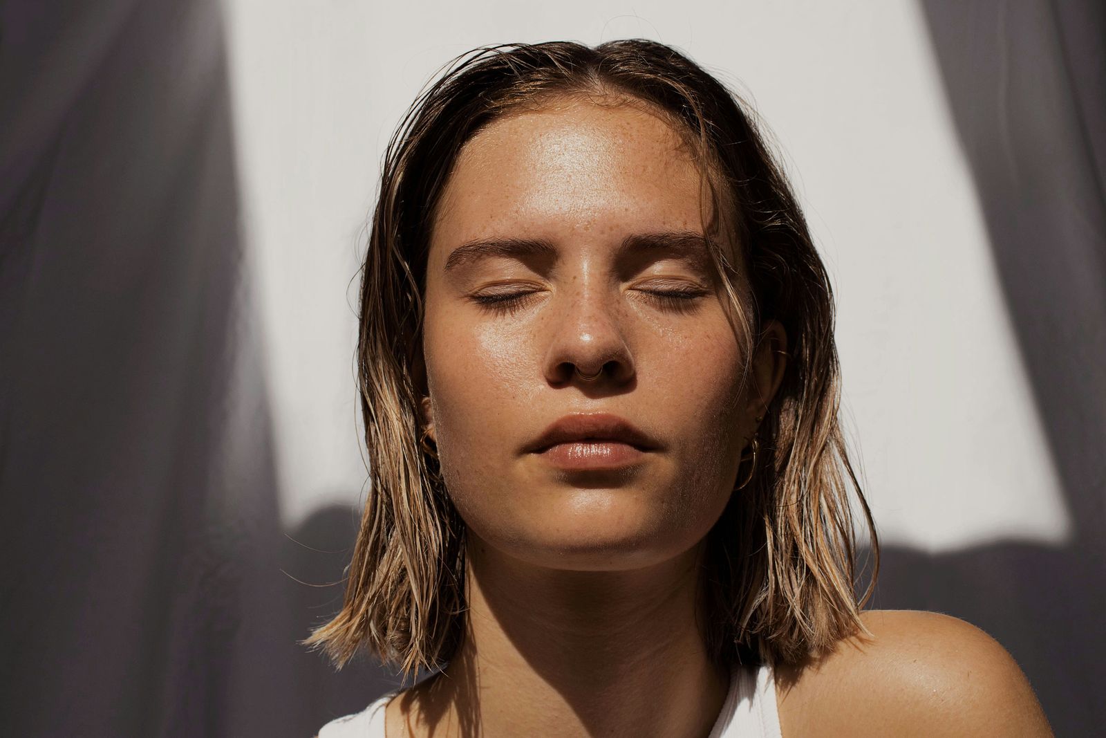 Woman with closed eyes in sunlight